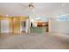 Spacious living area featuring carpet flooring, bright paint, and an open layout to the kitchen at 15313 W Pantano Dr, Surprise, AZ 85374