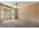 Bright main bedroom featuring three large windows, neutral paint, and carpet flooring at 15313 W Pantano Dr, Surprise, AZ 85374