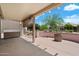 Covered patio with outdoor seating, mature landscaping, and relaxing backyard at 15313 W Pantano Dr, Surprise, AZ 85374