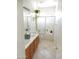 Bright bathroom featuring dual sinks, wooden cabinets, and a shower-tub combination at 15507 W Marconi Ave, Surprise, AZ 85374