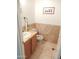 Tiled powder room with decorative marble wall, stylish fixtures, and unique cactus wall art at 15507 W Marconi Ave, Surprise, AZ 85374
