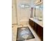 Well-lit bathroom featuring double sinks, dark wood cabinets, and a tub/shower combination at 15507 W Marconi Ave, Surprise, AZ 85374