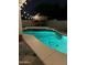 Backyard pool featuring a tiki hut and overhead string lights, creating a relaxing nighttime ambiance at 15507 W Marconi Ave, Surprise, AZ 85374