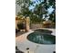 Backyard with a swimming pool, tiki hut, and outdoor seating area illuminated by string lights at dusk at 15507 W Marconi Ave, Surprise, AZ 85374