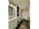 Well-lit bathroom features a double sink vanity with white cabinets and a tub with white tile at 15742 W Central St, Surprise, AZ 85374