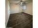 A bedroom has wood-look floors, white trim, a ceiling fan, and a window with white shutters at 15742 W Central St, Surprise, AZ 85374