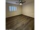 A bright bedroom features wood-look flooring, a ceiling fan, and a window with white shutters at 15742 W Central St, Surprise, AZ 85374