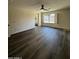 A bedroom featuring hardwood floors, a ceiling fan, and large windows overlooking the exterior at 15742 W Central St, Surprise, AZ 85374