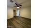 An empty bedroom has wood-look floors, a ceiling fan, and a closet with an open white door at 15742 W Central St, Surprise, AZ 85374