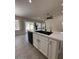 The open kitchen features quartz countertops, white cabinets, island seating and stainless dishwasher at 15742 W Central St, Surprise, AZ 85374