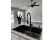 Close-up of a modern kitchen island featuring a stainless steel sink and updated faucet fixture at 15742 W Central St, Surprise, AZ 85374