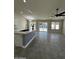 Open kitchen with an island, granite counters, stainless steel appliances, tile floors, and an adjacent seating area at 15742 W Central St, Surprise, AZ 85374