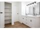 Modern bathroom with dual vanity, updated lighting, and linen closet at 16008 N 69Th Ln, Peoria, AZ 85382