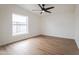 Bedroom featuring new hardwood flooring, a window, and modern ceiling fan at 16008 N 69Th Ln, Peoria, AZ 85382