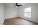 An airy bedroom features wood floors, a large window, and a modern ceiling fan at 16008 N 69Th Ln, Peoria, AZ 85382