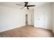 A bright bedroom features hardwood flooring, a ceiling fan, and closet at 16008 N 69Th Ln, Peoria, AZ 85382