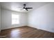 Bedroom features new hardwood flooring, large window, and ceiling fan at 16008 N 69Th Ln, Peoria, AZ 85382