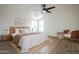Staged bedroom with wood flooring, ceiling fan, and natural light at 16008 N 69Th Ln, Peoria, AZ 85382