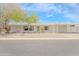 Inviting single-story home with a covered parking area and xeriscaped front yard featuring mature trees and desert plants at 16008 N 69Th Ln, Peoria, AZ 85382
