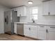 Updated kitchen with stainless steel appliances, white cabinets, and a large sink at 16008 N 69Th Ln, Peoria, AZ 85382