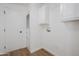 Bright laundry room features white cabinets and new hardwood flooring at 16008 N 69Th Ln, Peoria, AZ 85382