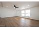 Bright, empty living room with wood floors, large windows, and ample space, offering endless possibilities for customization at 16008 N 69Th Ln, Peoria, AZ 85382