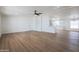 Spacious living room with wood floors, a ceiling fan, and an open layout to the kitchen, creating a welcoming atmosphere at 16008 N 69Th Ln, Peoria, AZ 85382