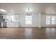 Bright open-concept living and kitchen area with modern light fixtures and new wood flooring at 16008 N 69Th Ln, Peoria, AZ 85382