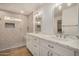 Modern bathroom showcasing a double vanity, quartz counters, updated fixtures, and a walk-in shower at 16120 N 86Th Ln, Peoria, AZ 85382