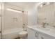 Bathroom featuring a shower-tub, a window, and vanity with a marble countertop at 16120 N 86Th Ln, Peoria, AZ 85382