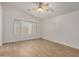 This bedroom features wood-look tile floors, a ceiling fan, a window and neutral paint at 16120 N 86Th Ln, Peoria, AZ 85382