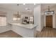 Beautiful kitchen showcasing a peninsula, white cabinets, modern lighting, and stainless steel appliances at 16120 N 86Th Ln, Peoria, AZ 85382