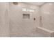 Updated shower showcasing a built-in bench, tiled walls, tiled floor, and rain shower head at 16120 N 86Th Ln, Peoria, AZ 85382