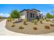 Beautifully landscaped front yard with decorative stone and mature trees framing this attractive single-Gathering home at 17376 W Wildwood St, Surprise, AZ 85388