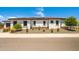 Attractive single-story home featuring desert landscaping, light stucco, and dark trim set against a bright, sunny sky at 17376 W Wildwood St, Surprise, AZ 85388