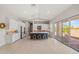 Spacious kitchen features white cabinets, an island with bar stools, stainless steel appliances, and sliding doors at 17376 W Wildwood St, Surprise, AZ 85388