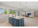 Kitchen island featuring a stainless steel sink, dishwasher, and view to an open living space at 17376 W Wildwood St, Surprise, AZ 85388