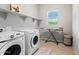 Bright laundry room with front loading washer and dryer and open shelving at 17376 W Wildwood St, Surprise, AZ 85388