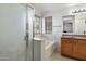 Well-lit bathroom featuring a shower, tub, and vanity, blending functionality with natural light at 17802 N 114Th Ln, Surprise, AZ 85378