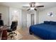 Bedroom with neutral walls, ceiling fan, and an adjacent bathroom, enhancing comfort and convenience at 17802 N 114Th Ln, Surprise, AZ 85378