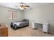 Bedroom with ceiling fan, large window, and a desk provides a comfortable and versatile space at 17802 N 114Th Ln, Surprise, AZ 85378