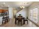 Open-concept dining area featuring a wood table, modern light fixture, and ample natural light at 17802 N 114Th Ln, Surprise, AZ 85378