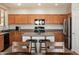 Well-lit kitchen features wood cabinets, stainless steel appliances, and a central island with bar seating at 17802 N 114Th Ln, Surprise, AZ 85378