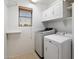 Bright laundry room featuring a new washer and dryer with convenient upper and lower cabinets at 17802 N 114Th Ln, Surprise, AZ 85378