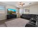 Comfortable living room with a sectional sofa, ceiling fan, and bright natural light at 17802 N 114Th Ln, Surprise, AZ 85378