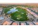 Aerial view of the golf course community featuring a large lake, lush green fairways and neighborhood homes at 1809 E Adelante Way, Queen Creek, AZ 85140