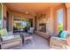 Covered patio with stone fireplace and comfortable wicker furniture perfect for entertaining at 1809 E Adelante Way, Queen Creek, AZ 85140