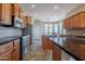 Spacious kitchen with stainless steel appliances, dark countertops, and ample cabinet space at 1809 E Adelante Way, Queen Creek, AZ 85140
