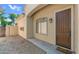 Inviting front entrance with a wooden door, decorative window, and landscaped surroundings at 2031 W Periwinkle Way, Chandler, AZ 85248