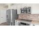 A modern kitchen featuring stainless steel appliances and light granite countertops at 2031 W Periwinkle Way, Chandler, AZ 85248